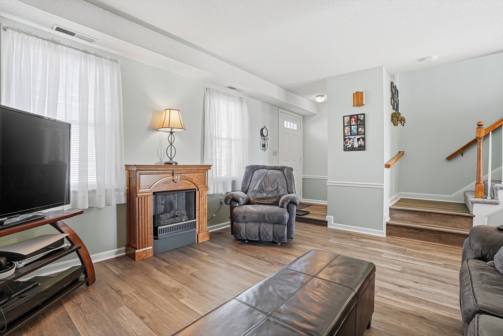 96 Century Way, Unit 96 Gardner, MA 01440 - Photo 14 of 41 a living room with furniture a flat screen tv and a fireplace
