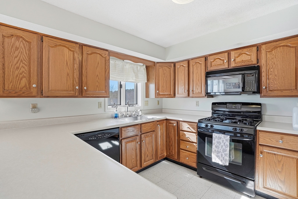 96 Century Way, Unit 96 Gardner, MA 01440 - Photo 19 of 41 a kitchen with stainless steel appliances granite countertop a sink stove and microwave