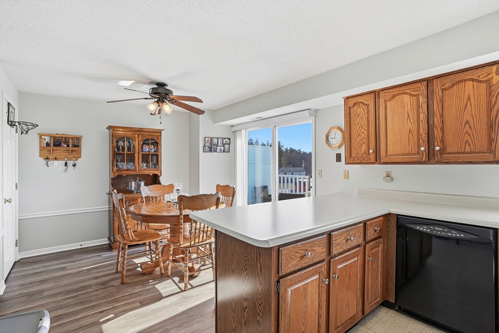 96 Century Way, Unit 96 Gardner, MA 01440 - Photo 21 of 41 a dining hall with stainless steel appliances granite countertop a dining table and chairs with wooden floor