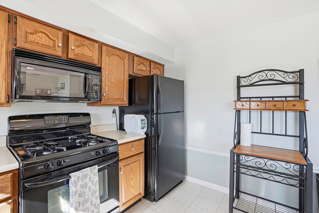 96 Century Way, Unit 96 Gardner, MA 01440 - Photo 24 of 41 a kitchen with stainless steel appliances granite countertop a stove a refrigerator and a microwave