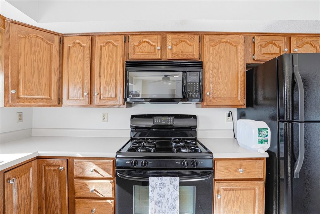 96 Century Way, Unit 96 Gardner, MA 01440 - Photo 25 of 41 a kitchen with stainless steel appliances wooden cabinets and a stove top oven