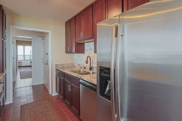 a kitchen with stainless steel appliances granite countertop a refrigerator and a sink