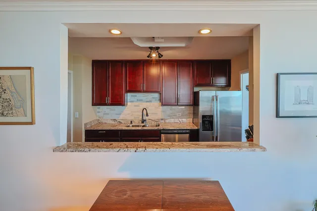 a kitchen with kitchen island a sink stainless steel appliances and cabinets