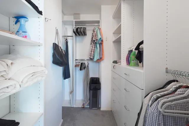 a view of walk in closet with clothes and shoes