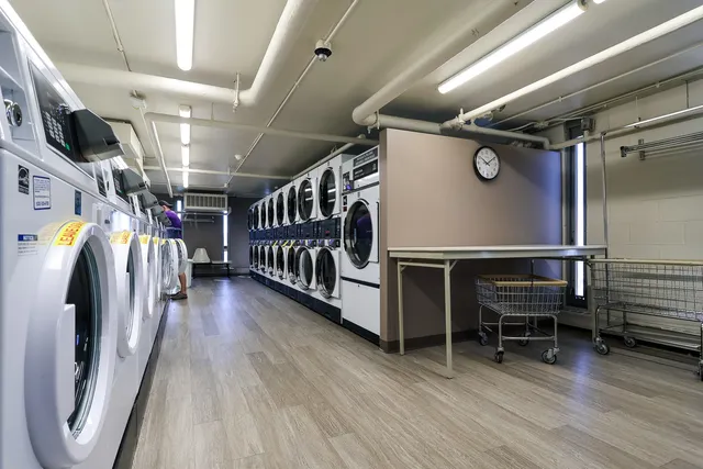 a view of an empty room with wooden floor and furniture