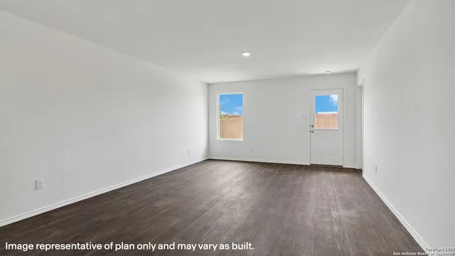 an empty room with wooden floor and window