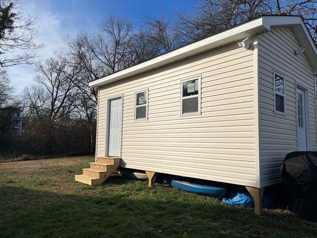 a view of backyard with barbeque grill and wooden fence