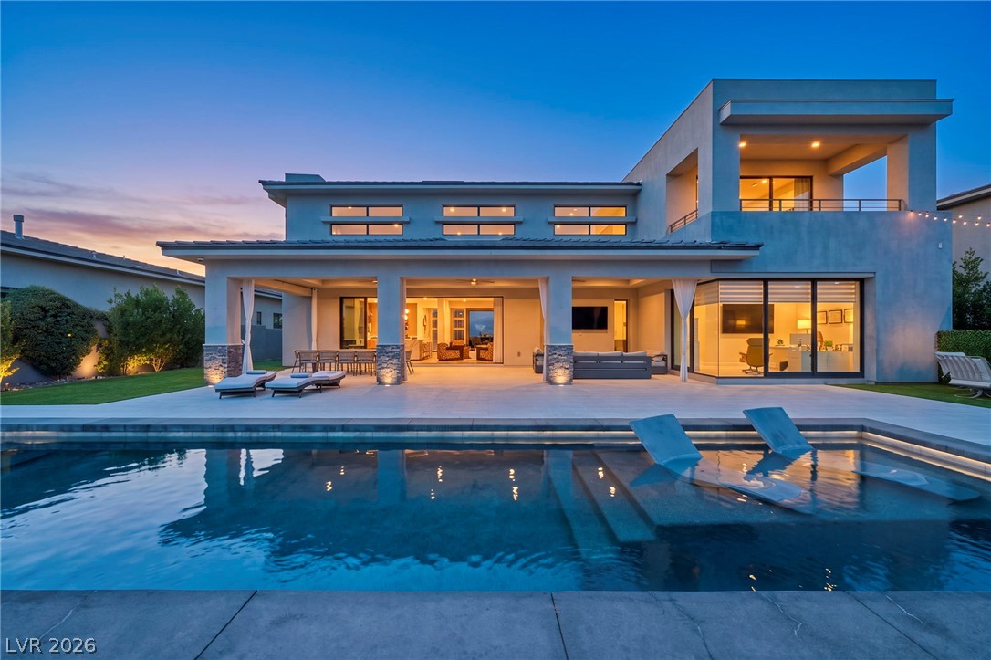 4208 Lapis Ridge Court Las Vegas, NV 89135 - Photo 56 of 61 Modern architectural lines frame a sleek swimming pool and expansive covered patio at twilight.