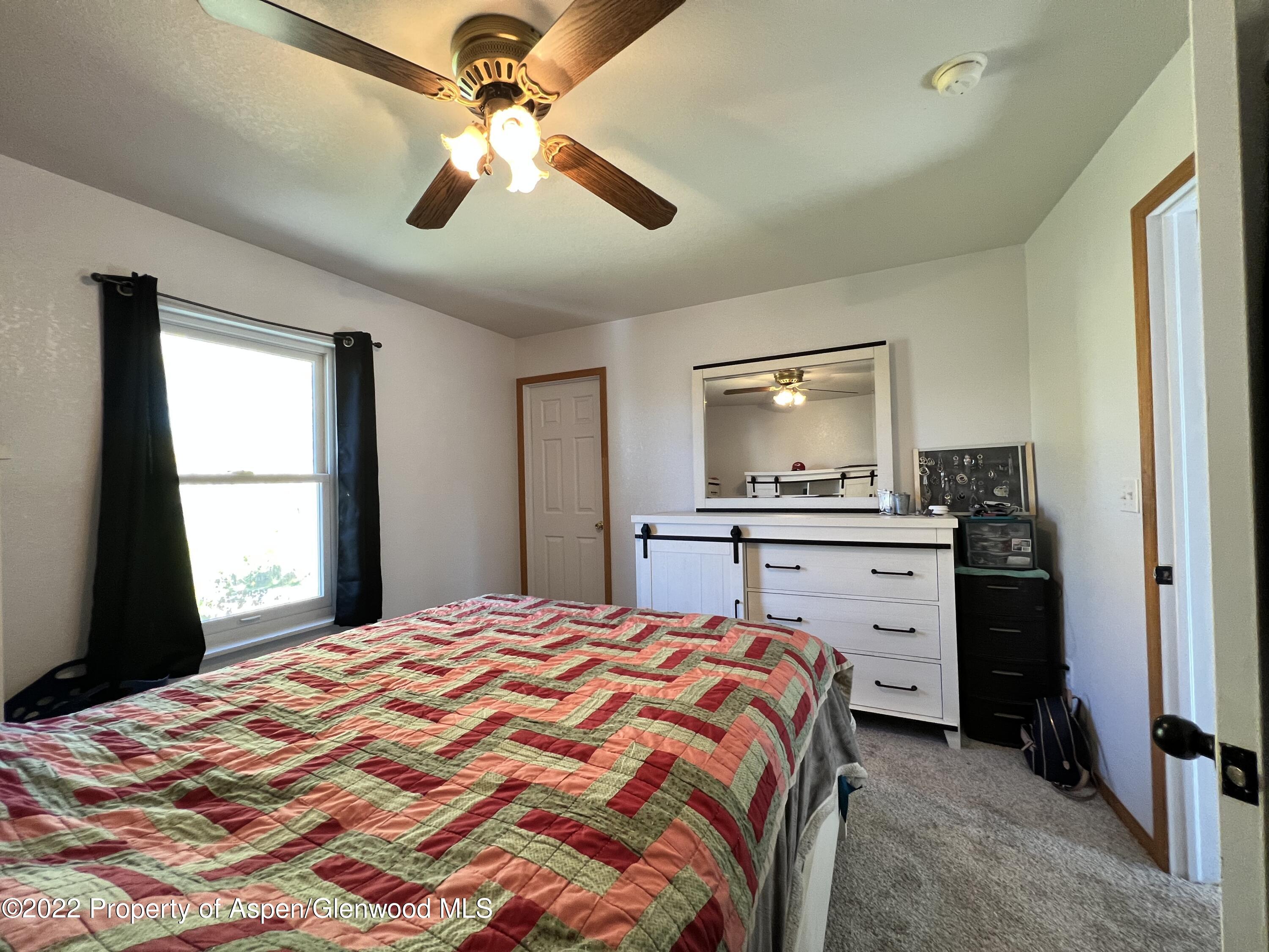 2447 Meadow Circle Rifle, CO 81650 - Photo 16 of 36 a bedroom with a bed and a flat screen tv