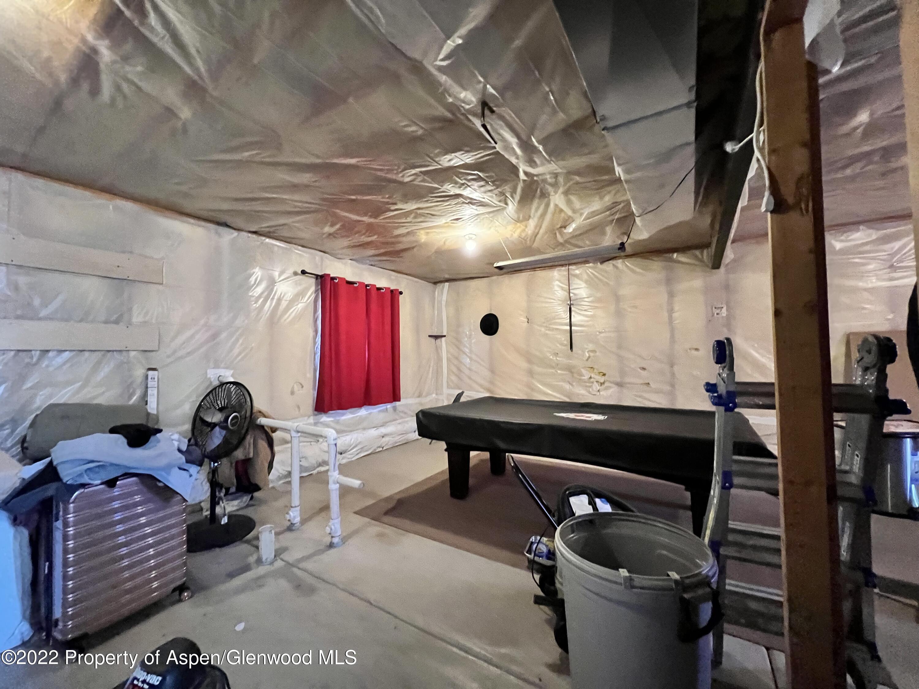 2447 Meadow Circle Rifle, CO 81650 - Photo 21 of 36 a room with lots of wooden furniture and a window
