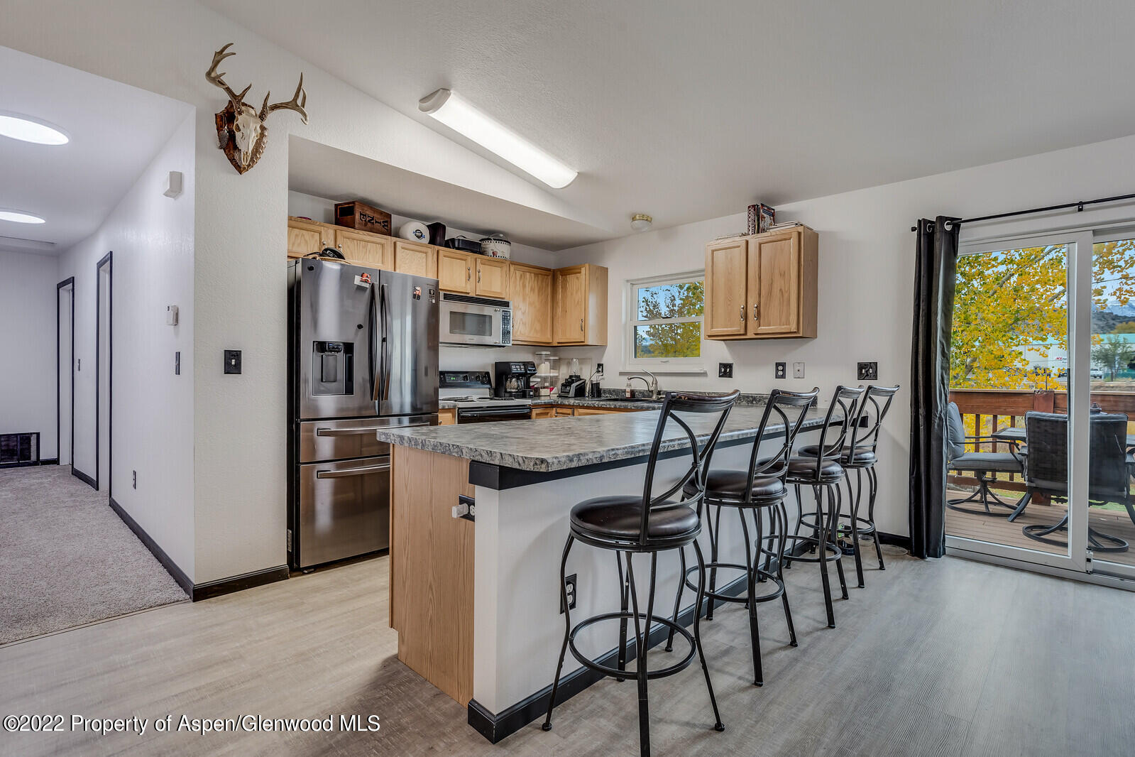 2447 Meadow Circle Rifle, CO 81650 - Photo 5 of 36 a kitchen with stainless steel appliances kitchen island granite countertop a refrigerator and microwave
