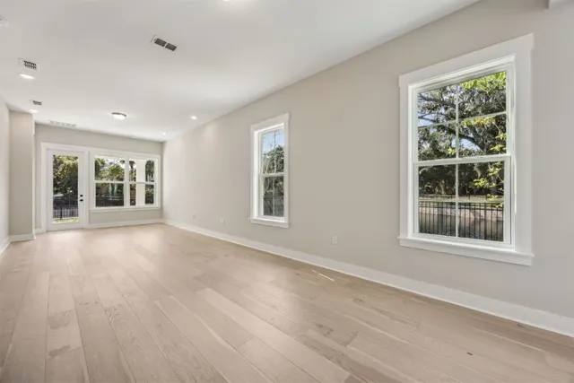 a view of kitchen with granite countertop refrigerator oven sink and white cabinets with wooden floor