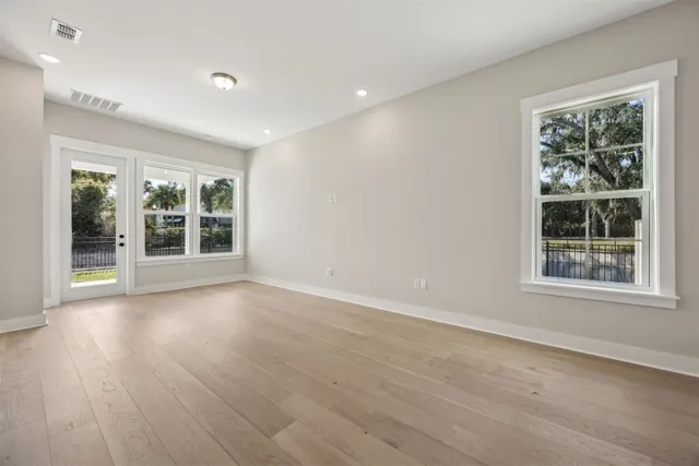 an empty room with wooden floor and a window