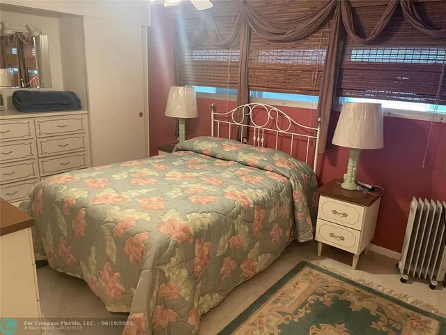 a bedroom with a bed and a dresser next to a window