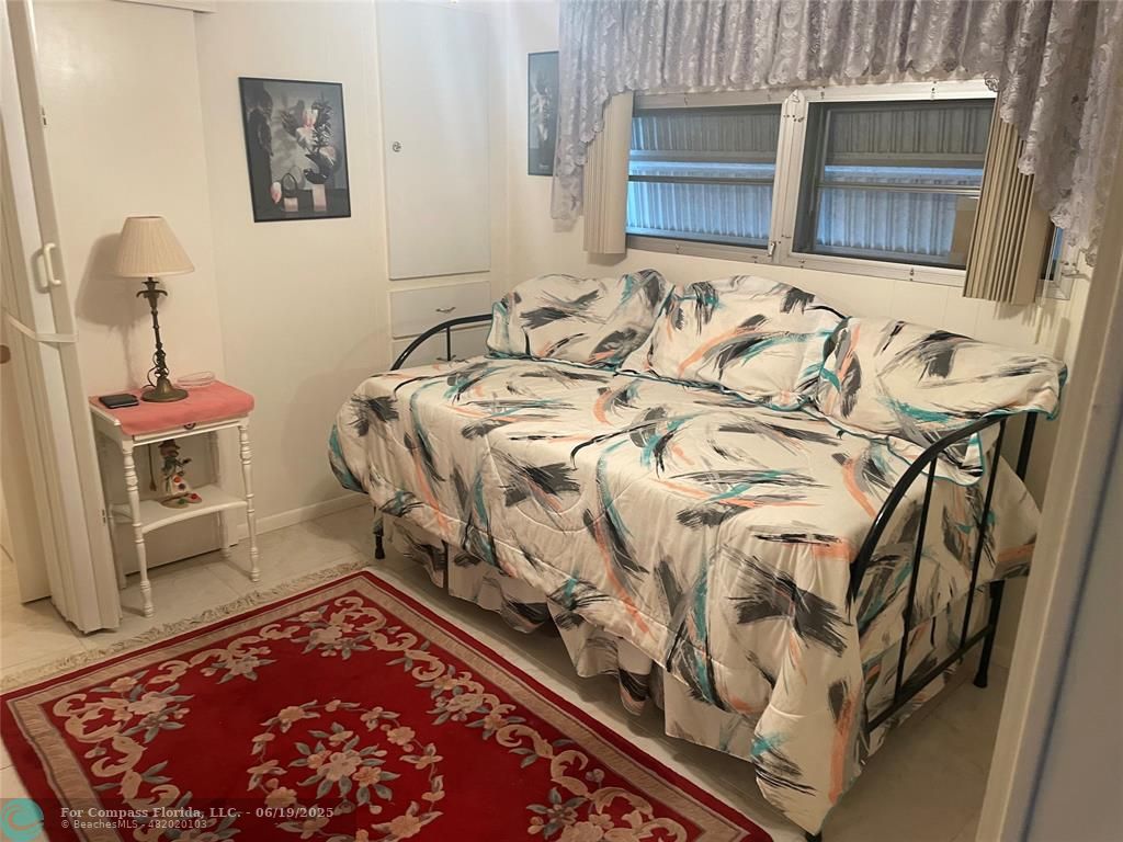 1888 Southwest 85th Avenue Davie, FL 33324 - Photo 14 of 18 a bed sitting in a bedroom next to a window with wooden floor