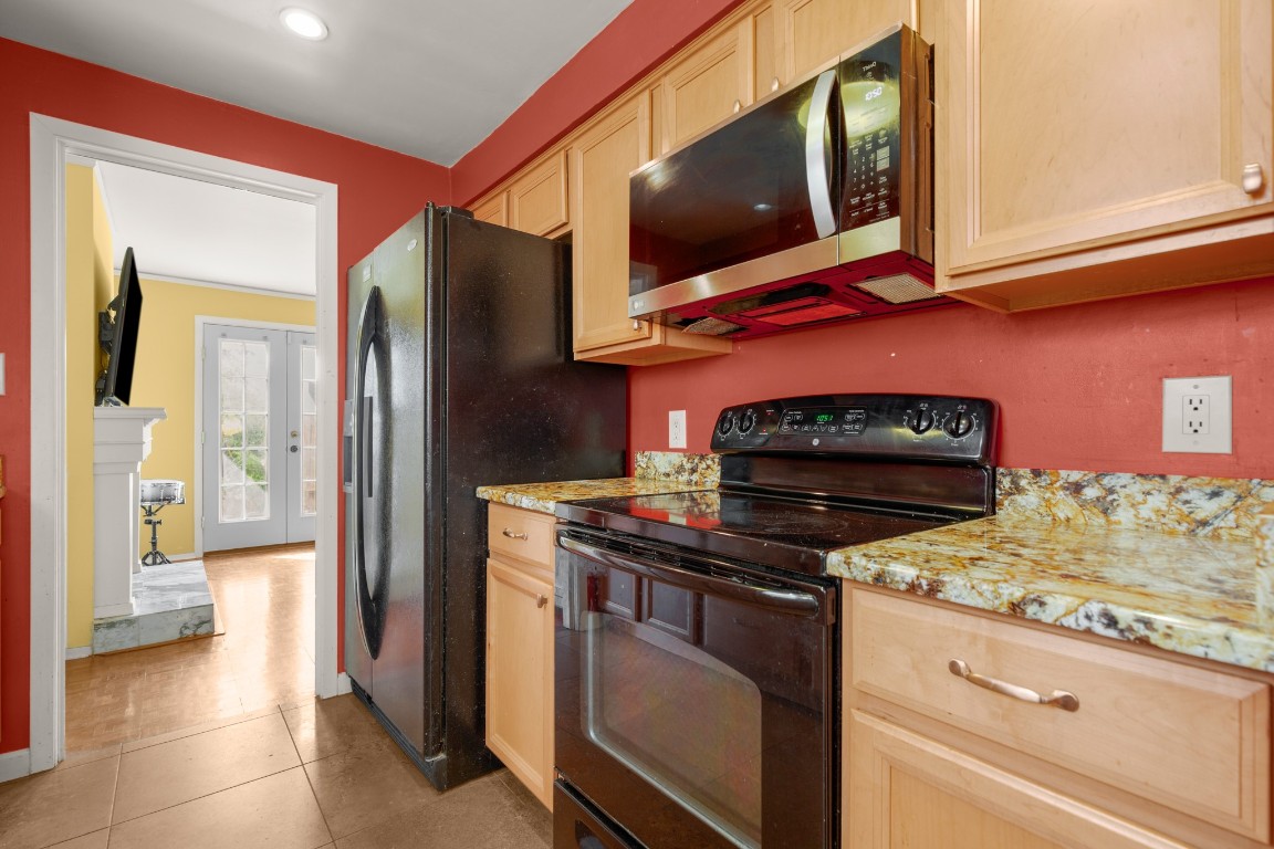 6631 Valleyside Road Austin, TX 78731 - Photo 15 of 33 a kitchen with stainless steel appliances granite countertop a stove and a microwave