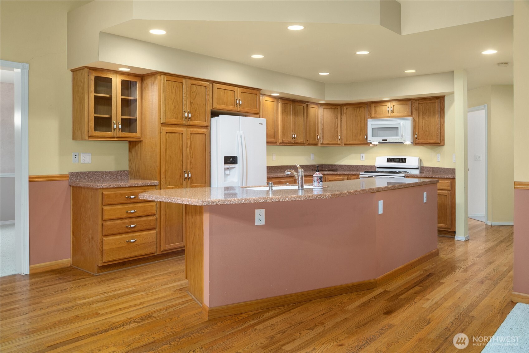 18663 Cascade Ridge Court Mount Vernon, WA 98274 - Photo 18 of 33 a kitchen with kitchen island granite countertop wooden floors and stainless steel appliances