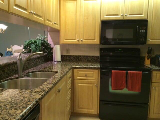 a kitchen with granite countertop a sink and a stove