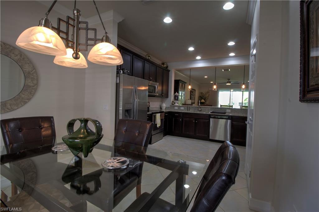 8472 Benelli Court Naples, FL 34114 - Photo 11 of 45 a kitchen with stainless steel appliances granite countertop a stove a refrigerator a sink dishwasher and a microwave