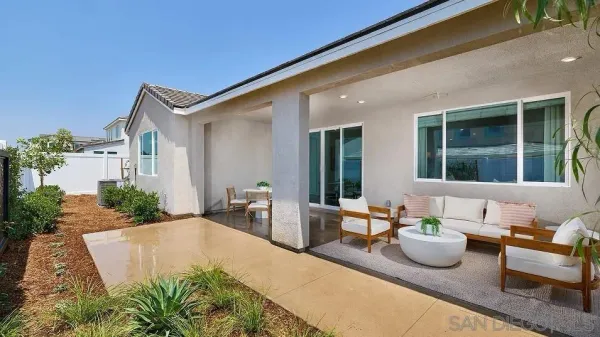a view of a patio with couches table and chairs and potted plants