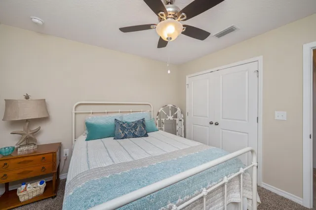 a bedroom with a bed and a lamp on dresser