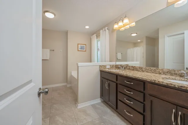 a bathroom with a granite countertop sink a large mirror and a shower