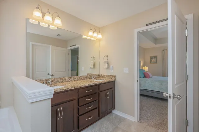 a en suite bathroom with a granite countertop sink and a mirror
