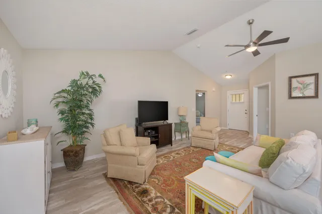 a living room with furniture a flat screen tv and a potted plant
