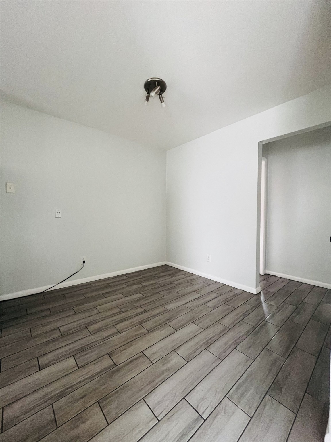 5123 Del Monte Drive, Unit 2 Houston, TX 77056 - Photo 8 of 12 a view of an empty room with wooden floor and a ceiling fan