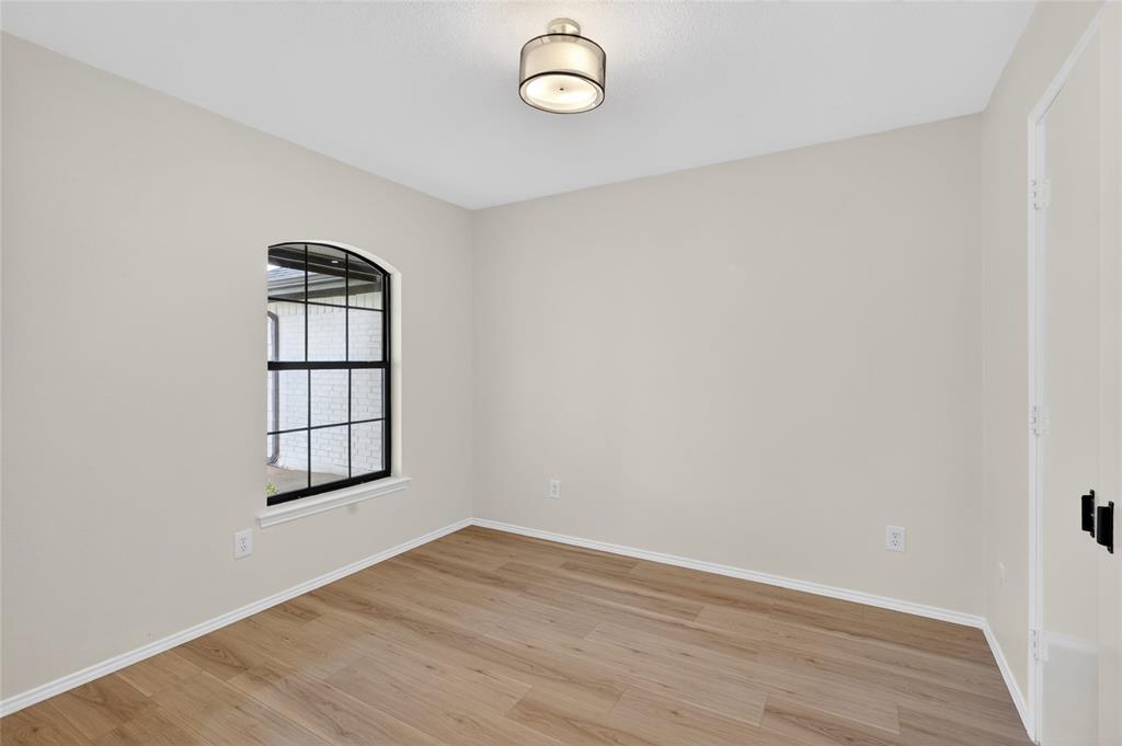 509 Brookside Court Burleson, TX 76028 - Photo 11 of 18 an empty room with wooden floor and windows