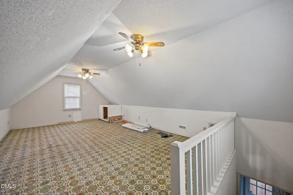a view of a room with a fireplace and ceiling fan