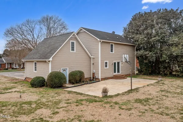 a view of backyard of a house with large trees