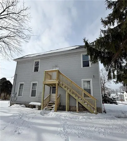 a view of a house with a wooden bench next to a road