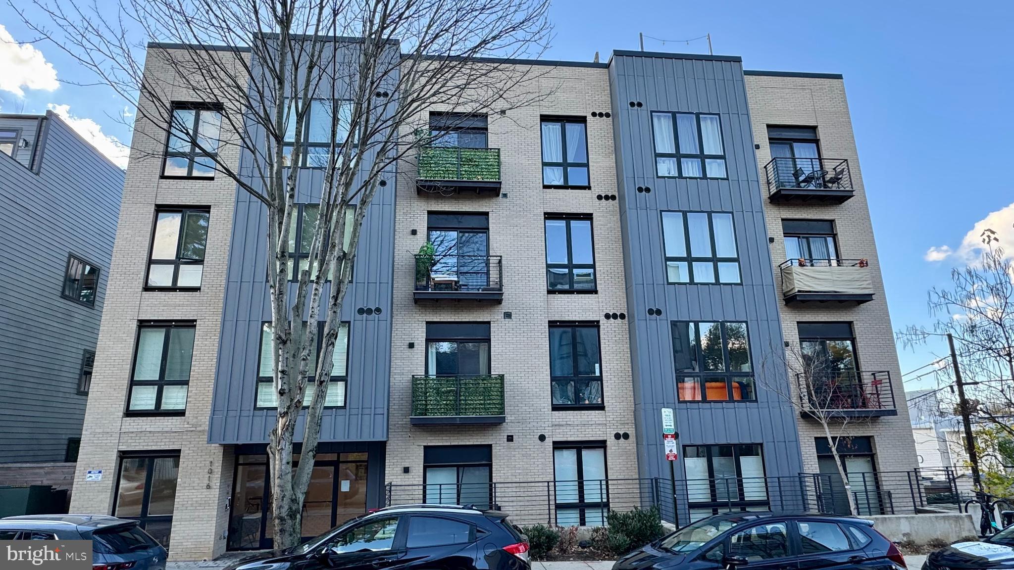 1016 17th Place Northeast, Unit 301 Washington, DC 20002 - Photo 1 of 12 a front view of a building with glass windows and a tree