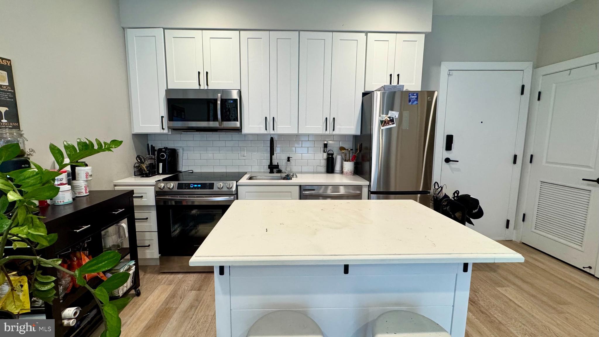 1016 17th Place Northeast, Unit 301 Washington, DC 20002 - Photo 4 of 12 a kitchen with stainless steel appliances a microwave a stove and refrigerator