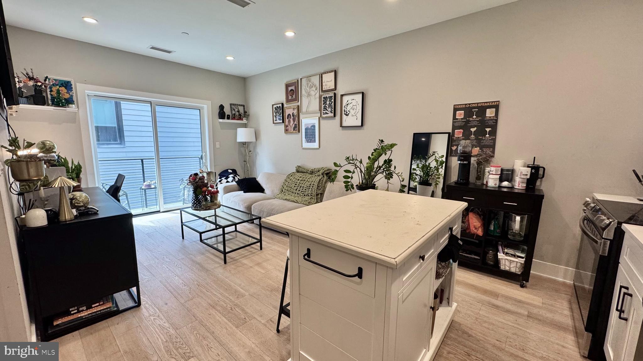 1016 17th Place Northeast, Unit 301 Washington, DC 20002 - Photo 7 of 12 a living room with furniture a table and wooden floor