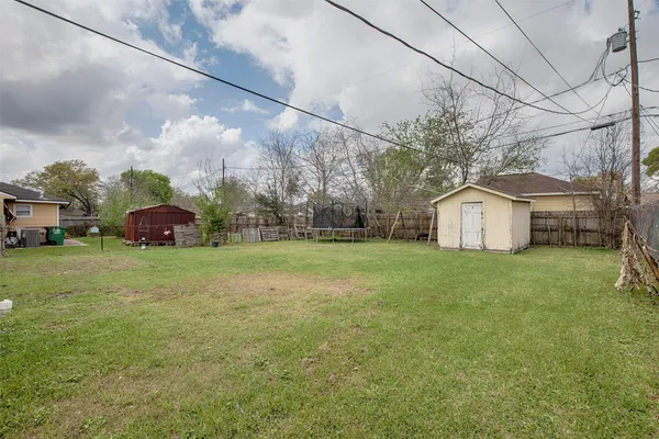 a yellow house sitting in middle of the grass