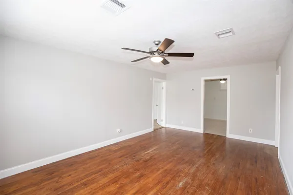 a view of an empty room with wooden floor