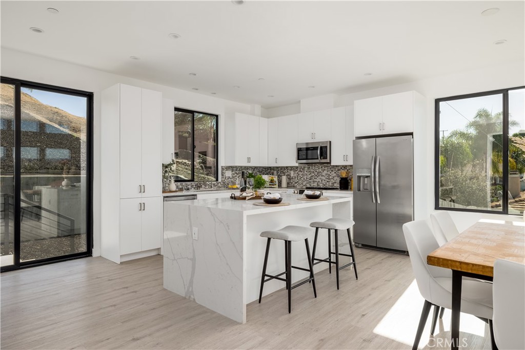 28896 Vacation Drive Canyon Lake, CA 92587 - Photo 10 of 39 a kitchen with stainless steel appliances granite countertop a refrigerator a stove and a dining table with wooden floor