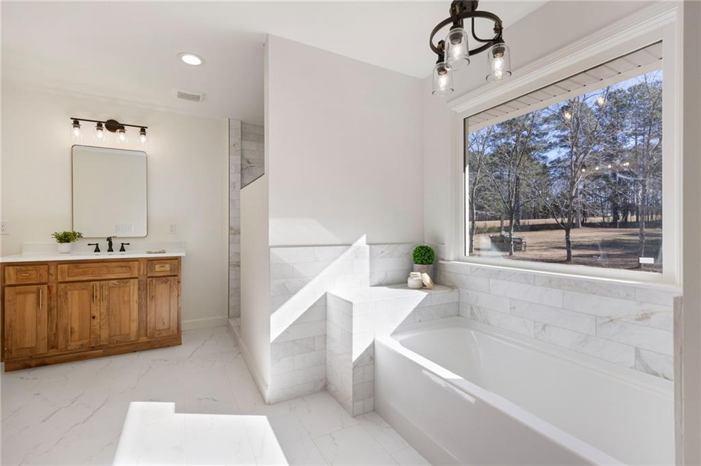 8277 Buchanan Highway Dallas, GA 30157 - Photo 9 of 36 a bathroom with a bathtub a sink and a window