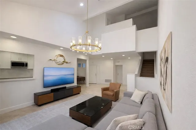 a living room with furniture a chandelier and a flat screen tv