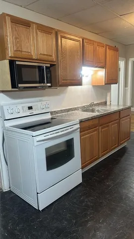 a kitchen with granite countertop a stove microwave and sink