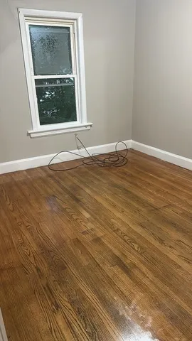 a view of a room with wooden floor and a window