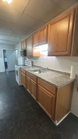 a kitchen with stainless steel appliances granite countertop a sink stove and cabinets