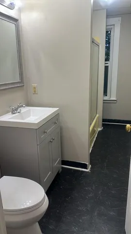 a bathroom with a toilet sink and mirror