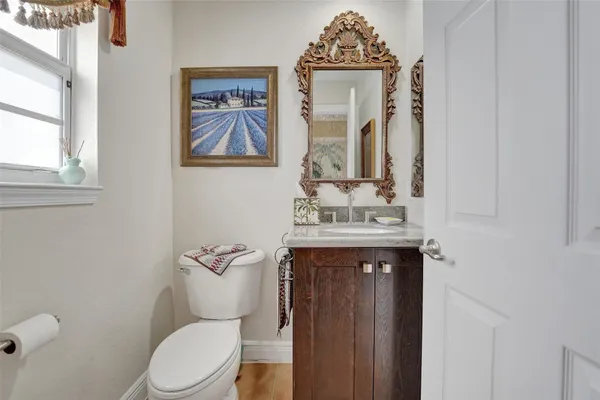 a bathroom with a granite countertop toilet sink and mirror