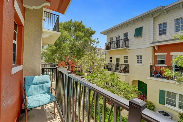 a balcony view with tall trees in front of it