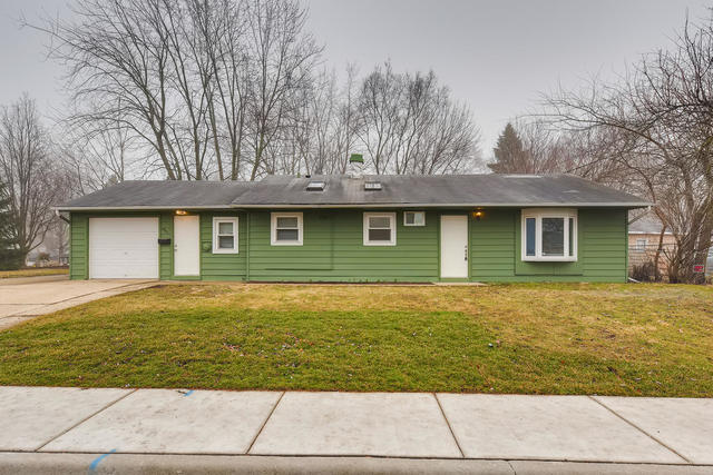 1923 Cherokee Road Carpentersville, IL 60110 - Photo 1 of 17 a front view of a house with a garden