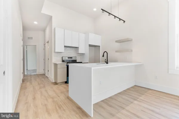 a kitchen with a sink cabinets and wooden floor