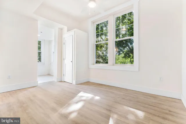 an empty room with windows and closet